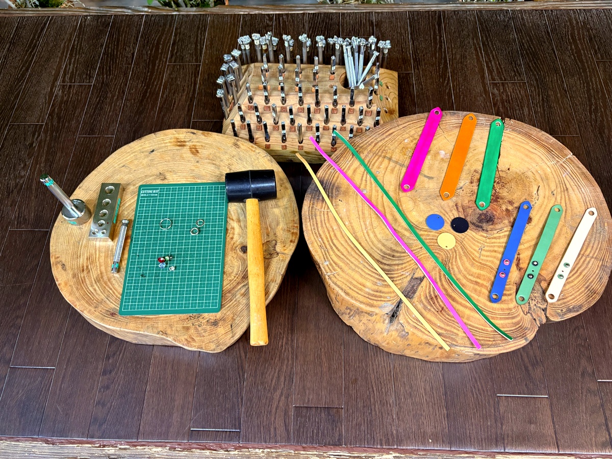 かんたん革細工体験で使用するゴムハンマーや刻印、革紐、きらきらストーンなどの道具と素材一式。